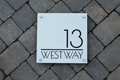 a sign that reads 13 westway on the side of a brick road with cobblestones