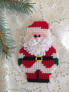 a santa clause ornament hanging from a pine tree