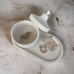 two wedding rings are placed in a white tray on the floor next to each other