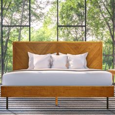 a bed with white pillows and wooden headboard