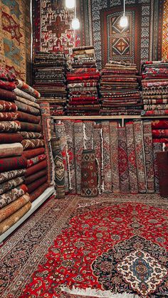 many rugs and carpets are stacked on the floor