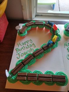 a birthday cake that is shaped like a train track