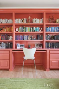 a chair sitting in front of a bookshelf filled with lots of bookcases