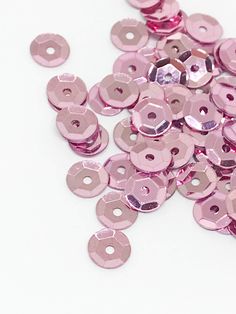 pink sequins are scattered on a white surface