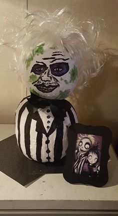 a creepy clown doll sitting on top of a counter next to a pillow and cushion