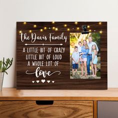 a family picture frame with string lights on it and the words, the yours family is a little bit of crazy