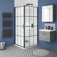 a bathroom with blue walls and black and white flooring, including a walk in shower