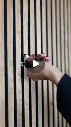 a person is opening the door with their thumb and pulling it up against the wooden slats