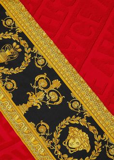 a red and black blanket with gold designs on it