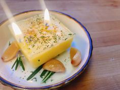 a plate with some food on it and two lit candles in the middle of it