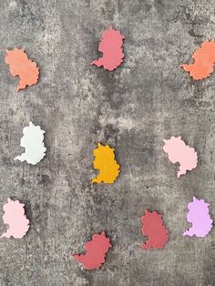 several different colors of paint on the ground next to each other with leaves painted on them