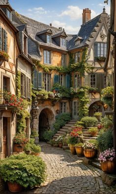 a cobblestone street with potted plants and flowers on either side of it