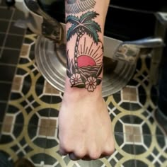 a person's foot with a tattoo on it and palm trees in the background