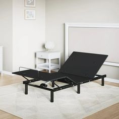 a black bed frame sitting on top of a white rug