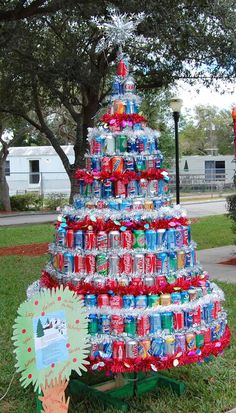 a christmas tree made out of cans in the grass