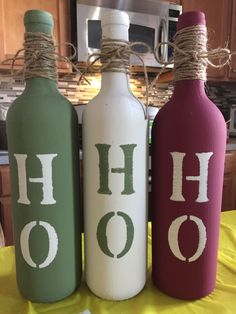 three wine bottles with the word hoo painted on them are sitting on a table