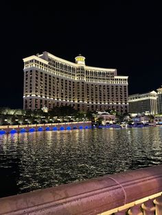 the hotel is lit up at night by the water in front of it's reflection