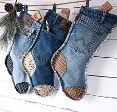 two pairs of jeans hanging from a rope with pine cones and candy canes in them