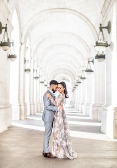 a man and woman are hugging in an archway