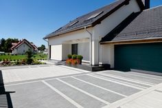 a house with a large driveway in front of it and two garages on the other side