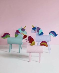 three paper mache unicorns are standing next to each other on a pink background