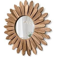 a wooden sunburst mirror hanging on the wall