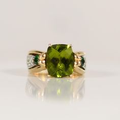 This stunning 14k yellow gold ring features a nearly 6-carat peridot, exquisitely cut into a rectangular cushion shape with a checkerboard top that catches and reflects light brilliantly. The peridot is framed by dazzling diamond accents that cascade down the sides of the shank, adding an extra layer of elegance and sparkle. This piece combines classic gold with the vibrant green of the peridot and the timeless allure of diamonds, making it a truly eye-catching and sophisticated accessory. Size: Rectangular Cushion, Ring With Diamond, Peridot Ring, Classic Gold, Vibrant Green, Yellow Gold Ring, Multi Stone Ring, Multi Stone, Yellow Gold Rings