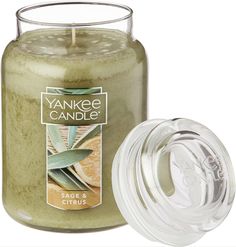 yankee candle with lid and glass jar next to it's packaging label on white background