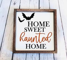 a framed sign that says home sweet and is decorated with bat's on it