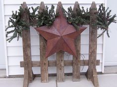 a wooden fence with a star and evergreens on it