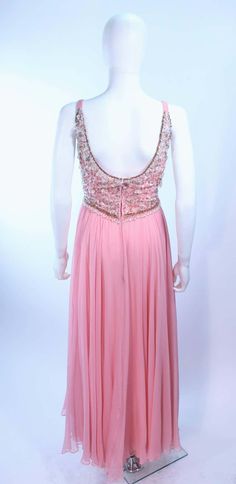 For Sale on 1stDibs - This I. Magnin gown is composed of a pink silk chiffon with a beaded bodice. There is a center back zipper closure. In excellent vintage condition. **Please Formal Pink Evening Dress With Sheer Bodice, Pink Formal Evening Dress With Sheer Bodice, Pink Chiffon Gown For Prom Season, Glamorous Pink Evening Dress With Lined Bodice, Pink Evening Dress With Sheer Bodice For Gala, Sleeveless Pink Evening Dress For Mother Of The Bride, Pink Sleeveless Evening Dress For Mother Of The Bride, Pink Chiffon Mother Of The Bride Dress For Evening, Pink Mother Of The Bride Dress For Evening Prom