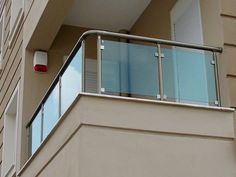 an apartment building with a balcony and balconies on the second floor that has glass railings