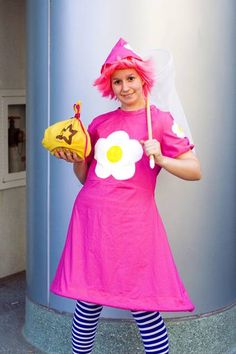 a woman dressed in pink holding a yellow banana