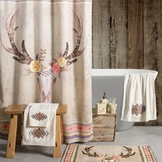 a bathroom with a deer head shower curtain, rug and bathtub in the background