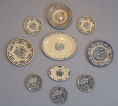 an assortment of blue and white plates arranged on a gray table top with silver trim around the edges