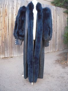 Fantastic Vintage navy blue leather and fox fur full length coat. Rocco D' Amelio for Dero Enterprises, Paris/New York. Avant Garde styling with full sleeves finished with a gauntlet leather cuff with four button closure. Fully lined in sumptuous blue satin.  Open front. Two deep side pockets. Striking silhouette. Size XL. Overall effect is navy blue, low sheen, soft leather.  Fox fur ridiculously soft, no flaws.  I have added a video to this listing to show the construction of the sleeves. The Gauntlet Leather, Alyssa Velaryon, Dramatic Silhouette, Full Length Coat, Fox Fur Coat, New Paris, Leather Cuffs, Full Sleeves, Blue Satin