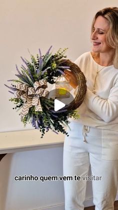 a woman holding a wreath with flowers in it