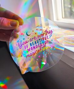 someone is holding up a holographic disc with the words you are worthy of beautiful wonderful magic