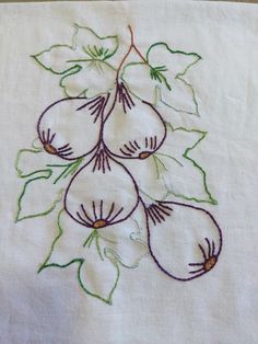 a white table cloth with embroidered flowers on it