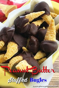 peanut butter stuffed bugles in a yellow bowl on a wooden table with chocolate chips