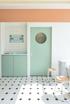 a kitchen with pastel colors and black and white flooring