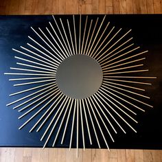 a coffee table with an artistic design on it's top and the reflection of a sunburst in the center