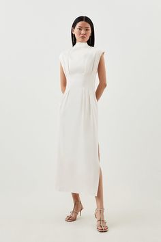 The Epitome Of Contemporary Elegance, This Maxi Dress Boasts A Tactile Bow-Tie Back That Creates Draped Depth To The Close-Fitting Silhouette. Made Of Tactile Satin, This Piece Has A High Neck With Wide Shoulders, Balancing The Gathered Bodice, Fitted Waist, And Side-Split Skirt.High Neckpleated Bodicebow-Tiebackfitted Waistsplit Sidemaxi Length Elegant Maxi Dress With Fitted Bodice For Daywear, Elegant Fitted Daywear Dresses, Elegant Fitted Dresses For Daywear, Fitted Feminine Maxi Dress For Workwear, Modest Graduation Dress, Petite Wedding Guest Dresses, Wide Shoulders, High Neck Maxi Dress, Gathered Bodice