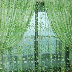 the window is covered with green curtains and drops of rain falling on the windowsill