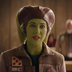 a woman with green hair wearing a brown jacket and headgear in the movie star wars