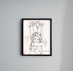 a black and white drawing of a woman hanging upside down on a wall above a bed