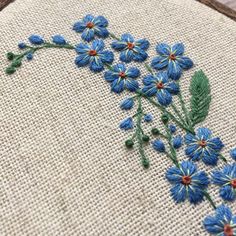 a close up of a cross stitch pattern with blue flowers