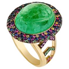 A classic shaped Emerald Cabochon was recreated into a modern piece with this 18k yellow gold ring. The 12.62 centre stone is decorated with a halo of pave’d Emeralds, Pink, Purple and Violet Sapphires. A chevron pattern of pave’d stones also enhance the band, giving it a modern look. Size: 53 ( Approx. 6.5 US) This ring can be sized to the customer's specifications with compliments. Blank Mind, Cocktail Ring Designs, Emerald Cabochon, Full Finger Rings, Colored Stone Rings, Tanzanite Stone, Diamond Cocktail Rings, Cabochon Ring, White Gold Diamond Rings