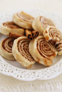 cinnamon rolls on a plate with cinnamon sticks