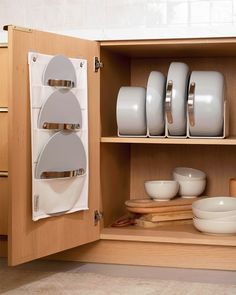 an open cabinet with plates and bowls in it